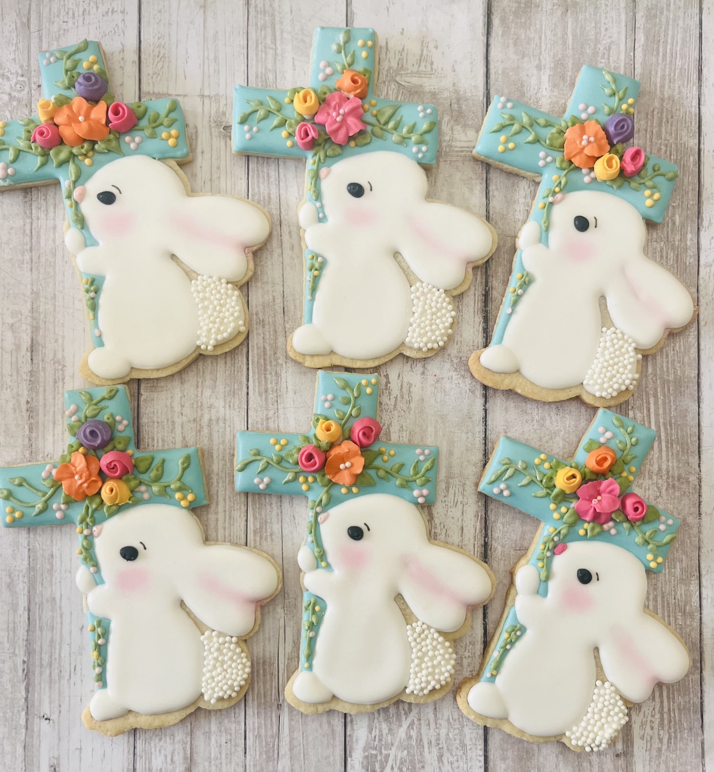 White Easter bunny cookies beside floral cross cookies