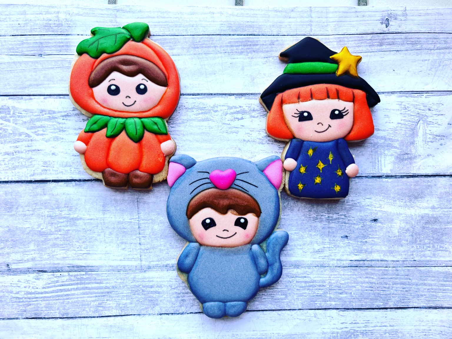 Pumpkin, witch, and cat costume character cookies