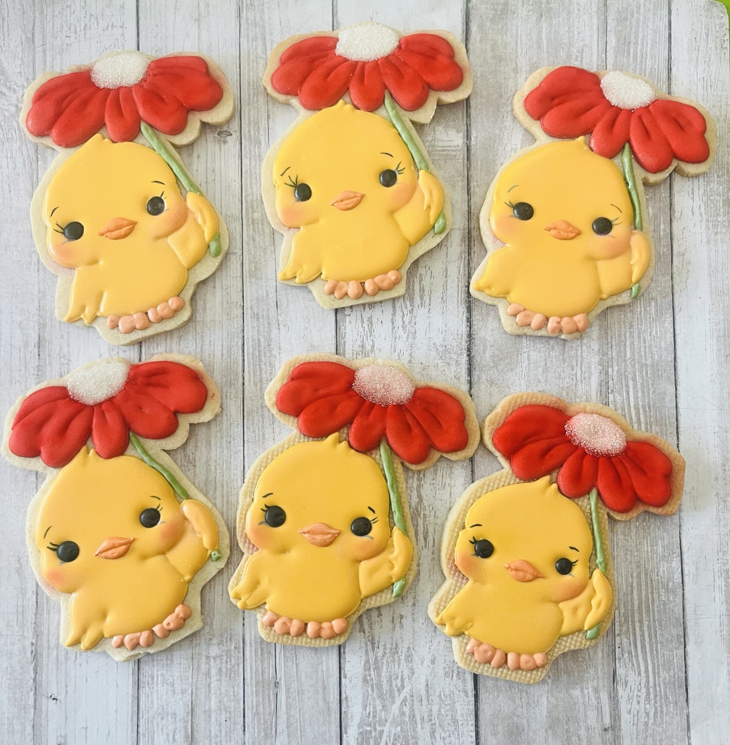 Yellow chick cookies holding red flowers